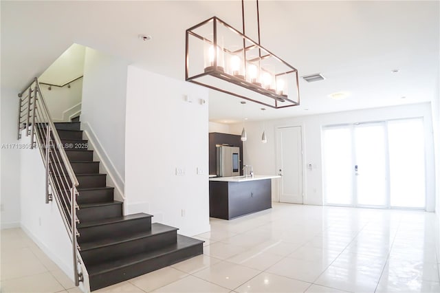 stairway with tile patterned floors and sink