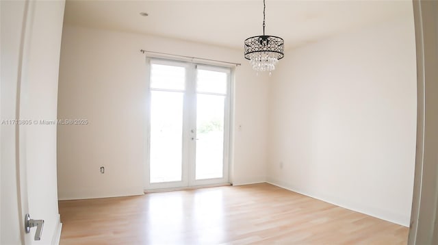 unfurnished room with light hardwood / wood-style flooring and an inviting chandelier