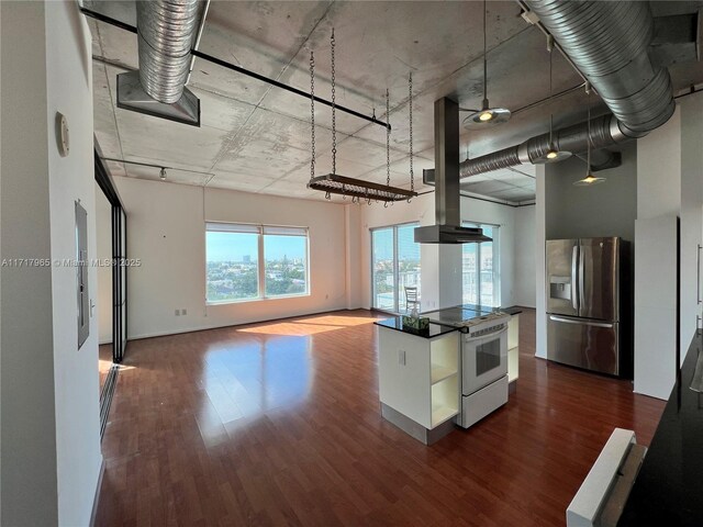 kitchen with a towering ceiling, white appliances, white cabinetry, and dark hardwood / wood-style flooring