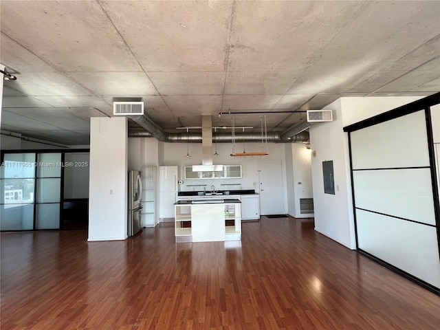 kitchen with stainless steel fridge, white cabinetry, electric panel, dark hardwood / wood-style floors, and decorative light fixtures