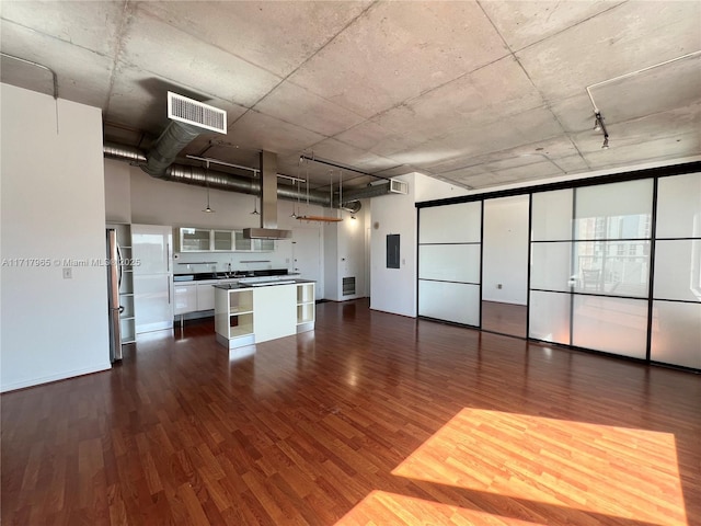 kitchen featuring stainless steel refrigerator, dark hardwood / wood-style flooring, electric panel, a kitchen island, and white cabinets