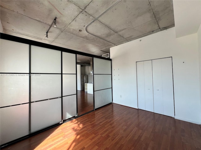 unfurnished bedroom featuring wood-type flooring and a closet