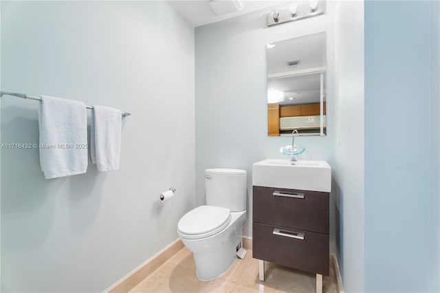 bathroom with toilet, vanity, and tile patterned floors