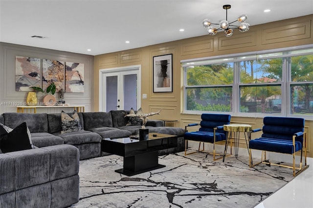 living room with a notable chandelier, a wealth of natural light, and french doors