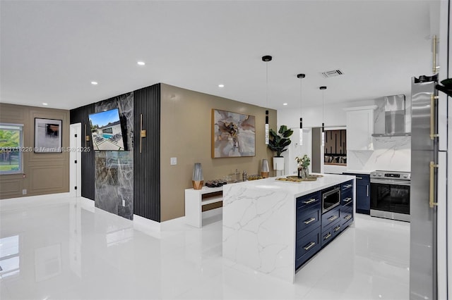 kitchen featuring wall chimney exhaust hood, a center island, hanging light fixtures, and appliances with stainless steel finishes