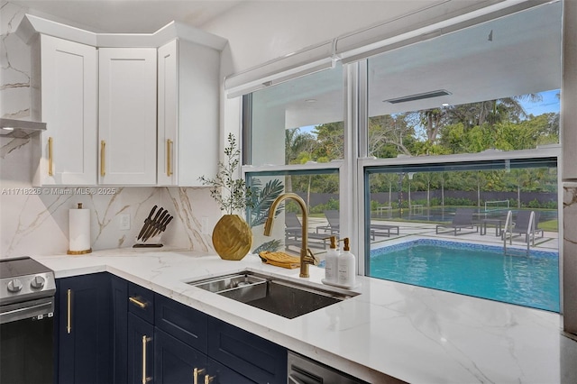 kitchen with white cabinetry, electric stove, sink, and tasteful backsplash