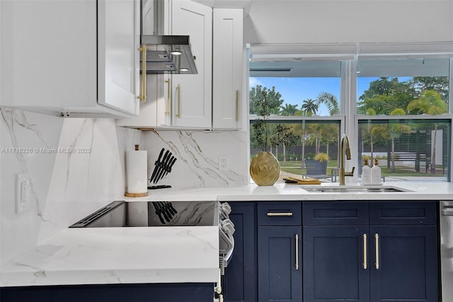 kitchen featuring light stone countertops, tasteful backsplash, sink, white cabinets, and range