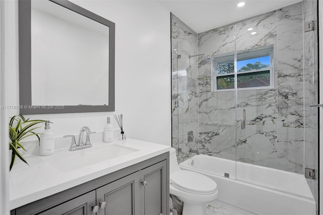 full bathroom featuring combined bath / shower with glass door, toilet, and vanity