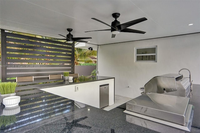 view of patio / terrace featuring area for grilling, ceiling fan, and exterior kitchen