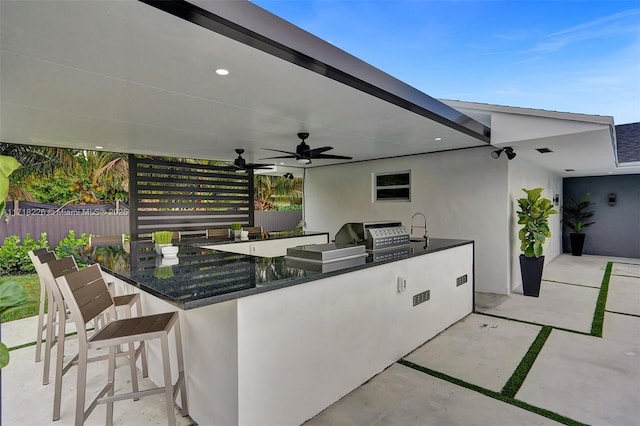 view of patio featuring ceiling fan, area for grilling, exterior bar, and grilling area