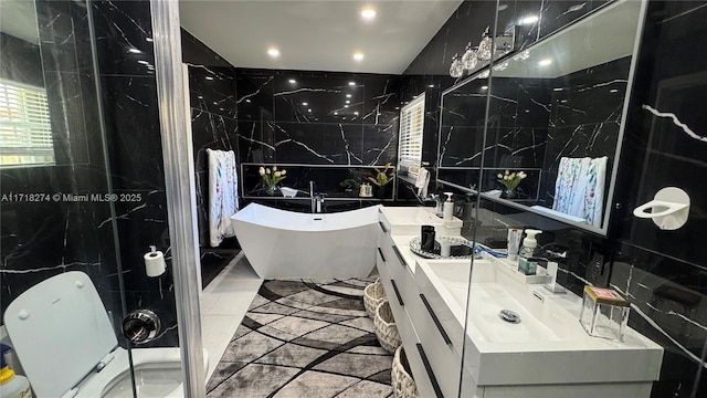 bathroom with tile walls, a washtub, and vanity