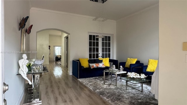 living room with french doors, ornamental molding, and wood-type flooring