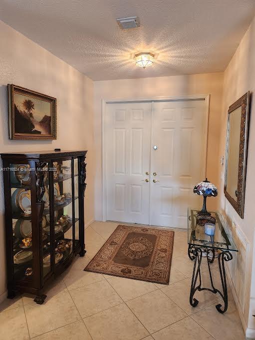 tiled entrance foyer with a textured ceiling