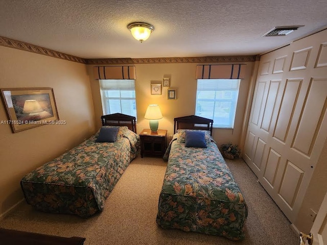 bedroom featuring carpet and a textured ceiling