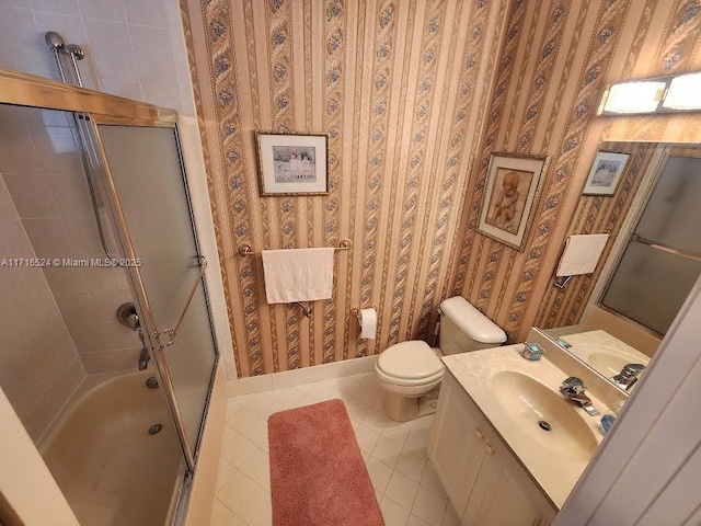 full bathroom featuring tile patterned floors, vanity, toilet, and bath / shower combo with glass door