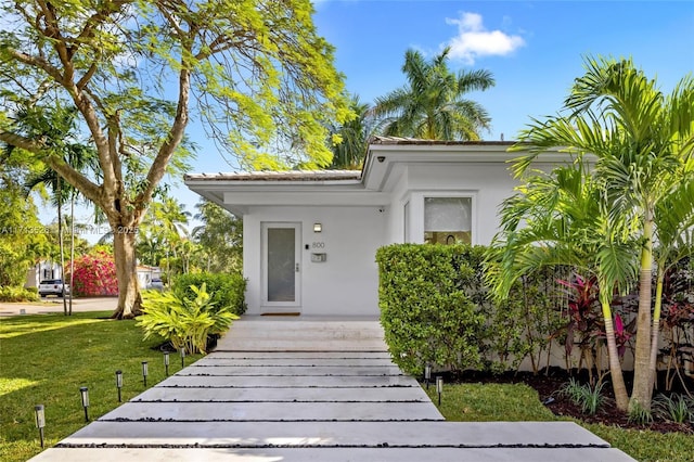 doorway to property with a yard