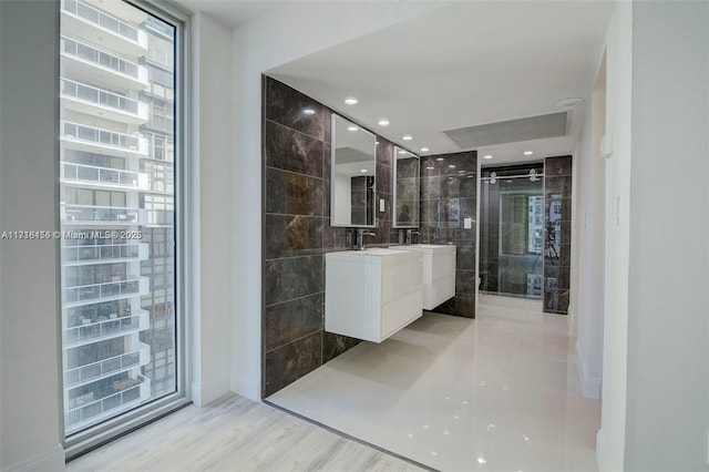 bathroom with vanity, a wall of windows, wood-type flooring, and tile walls