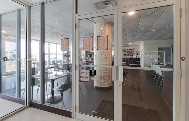 interior space with tile patterned floors and a drop ceiling