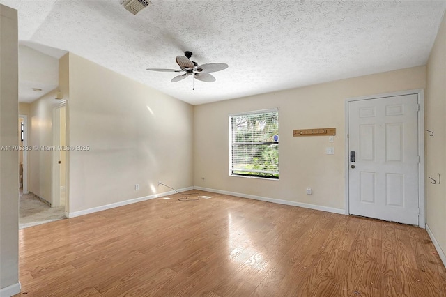 spare room featuring a textured ceiling, ceiling fan, and light hardwood / wood-style floors