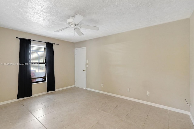 tiled empty room featuring ceiling fan and a textured ceiling