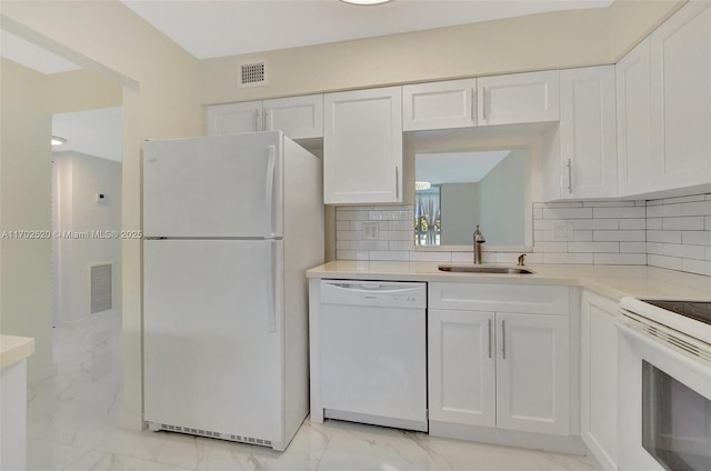 kitchen with white cabinets, decorative backsplash, white appliances, and sink