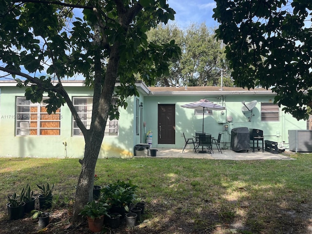 back of property with a lawn, a patio area, and central air condition unit