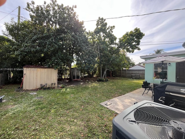 view of yard featuring central AC unit, a shed, and a patio