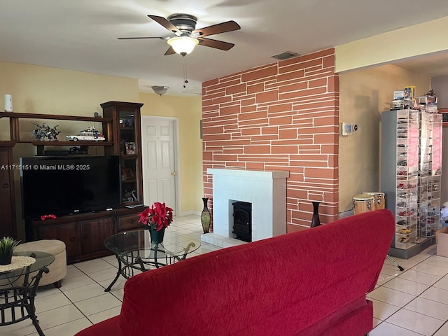 living room featuring ceiling fan, light tile patterned flooring, and a brick fireplace