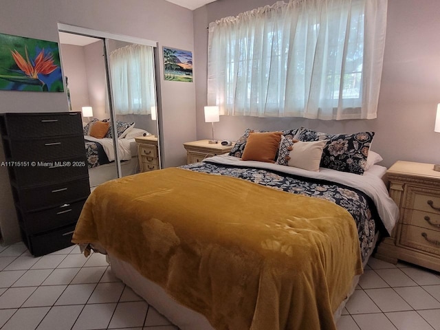 bedroom with light tile patterned floors and a closet