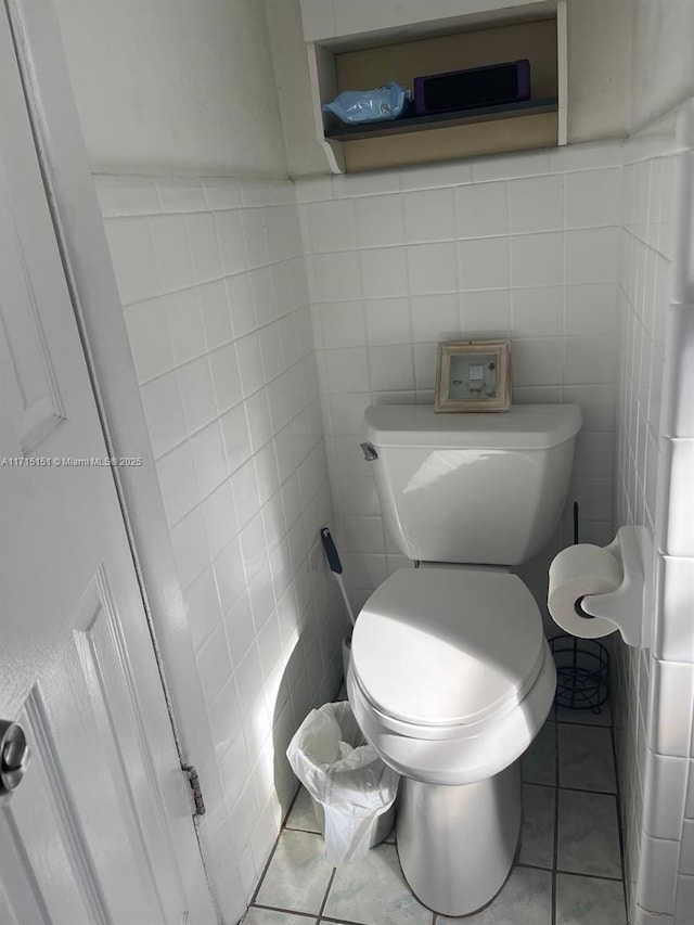 bathroom with tile patterned floors, tile walls, and toilet