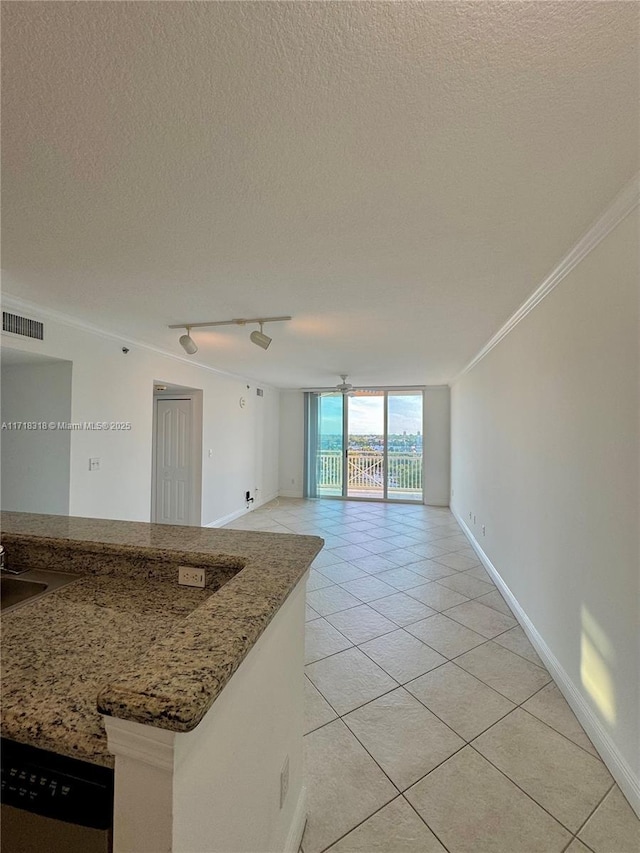 interior space with light tile patterned flooring, crown molding, track lighting, and a textured ceiling