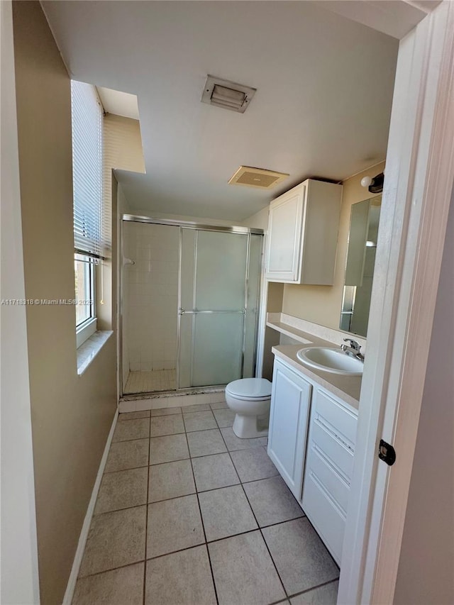 full bathroom featuring vanity, baseboards, tile patterned flooring, a shower stall, and toilet