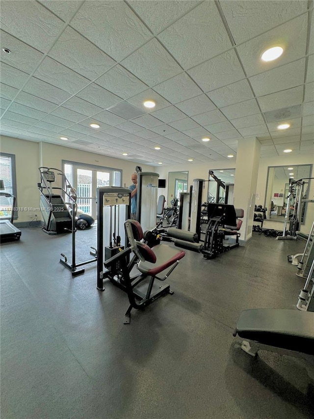 workout area featuring recessed lighting, a drop ceiling, and baseboards