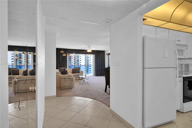 hallway with a textured ceiling and light colored carpet