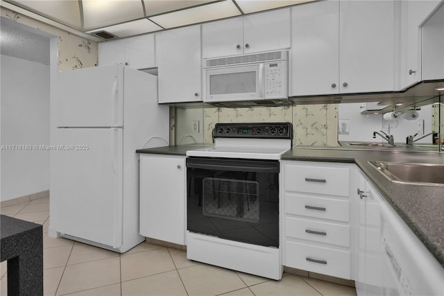 kitchen with white cabinetry, white appliances, sink, and light tile patterned floors