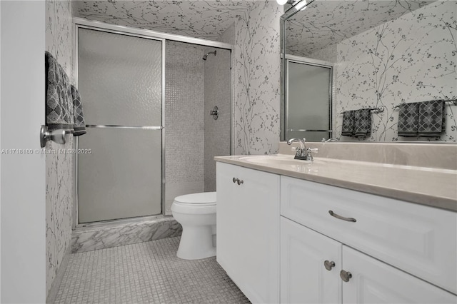 bathroom featuring tile patterned flooring, vanity, toilet, and walk in shower