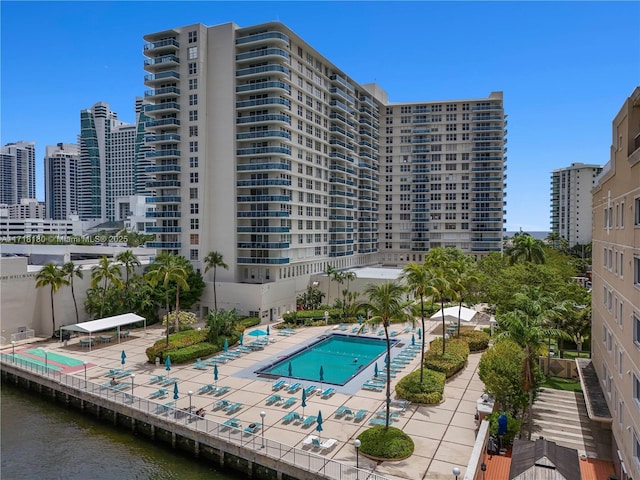 view of swimming pool featuring a water view and a patio