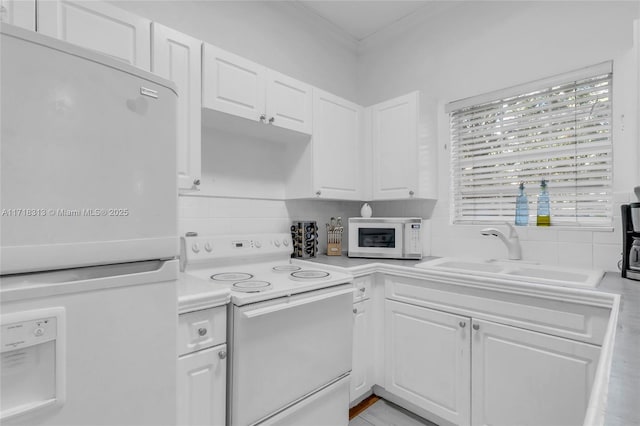 kitchen featuring white cabinetry, white appliances, sink, and tasteful backsplash