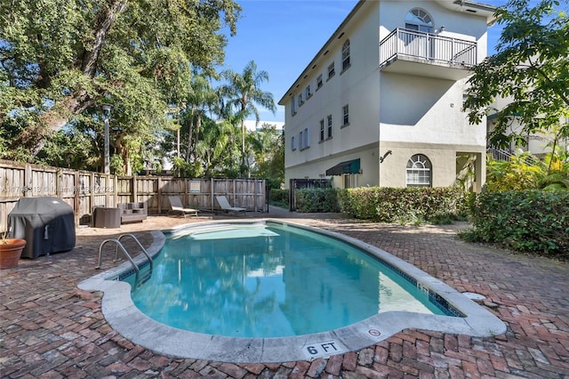 view of pool featuring a grill and a patio