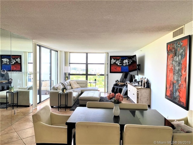 tiled living room featuring floor to ceiling windows and a textured ceiling