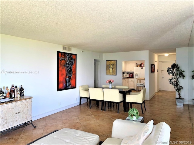 living room featuring a textured ceiling and light tile patterned flooring