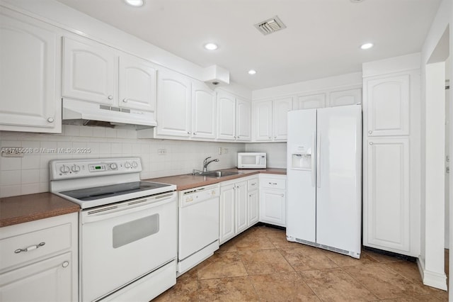 kitchen featuring visible vents, white cabinetry, a sink, white appliances, and under cabinet range hood