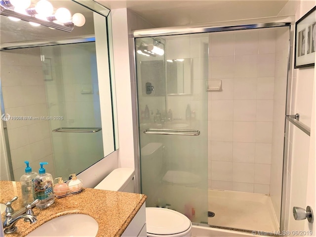 bathroom with vanity, toilet, and walk in shower