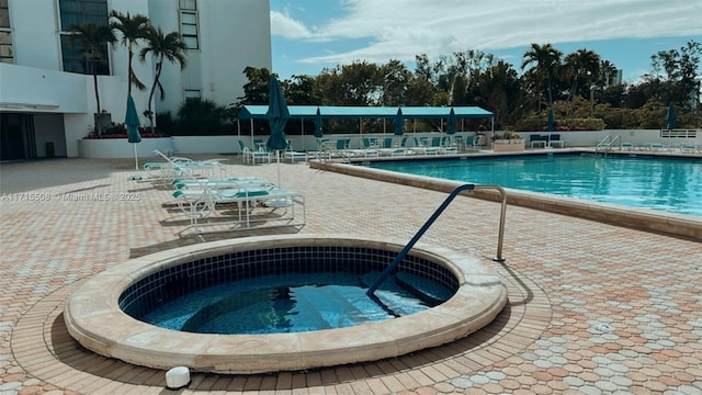 view of pool with a patio and a hot tub