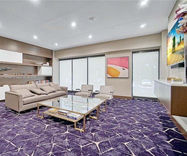 living area with recessed lighting, visible vents, and dark carpet