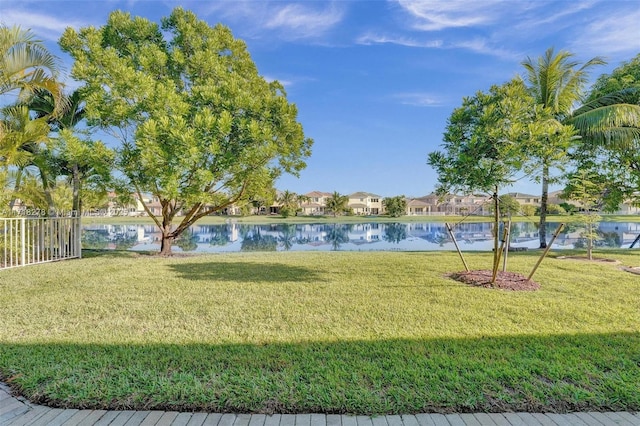 view of property's community with a water view and a lawn