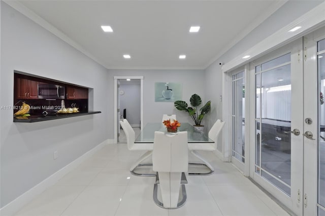 tiled dining space featuring crown molding and french doors