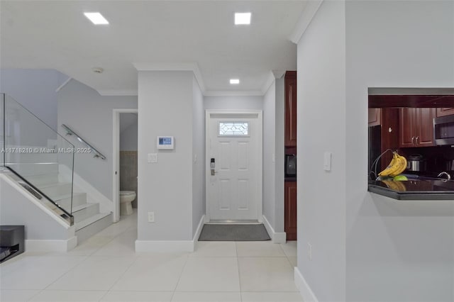 tiled foyer entrance with ornamental molding