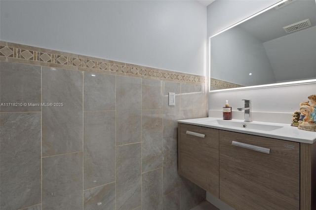 bathroom with vanity and tile walls