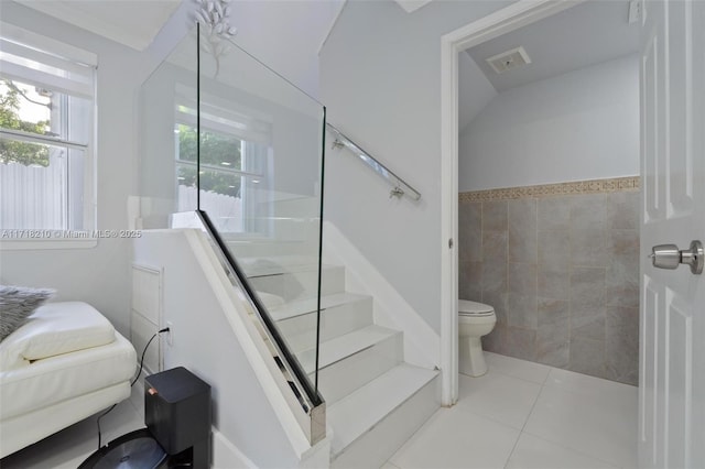 stairs featuring a wealth of natural light and tile patterned flooring